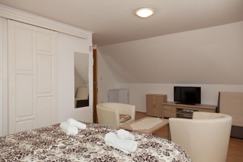 a room with a table and chairs and a television at Guest House Ljubica in Rastovača