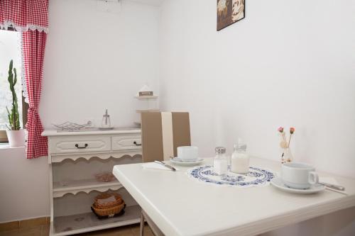 拉斯托瓦察的住宿－柳比旅館，一张带两个杯子和盘子的白色桌子