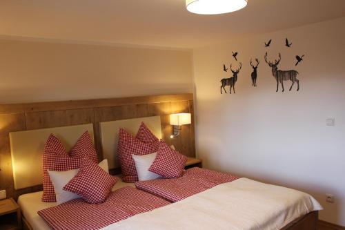 1 dormitorio con 1 cama con almohadas rojas y blancas en Ferienhof Bernegglehen en Berchtesgaden