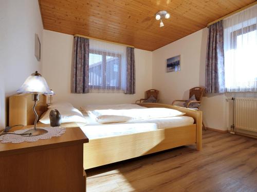 1 dormitorio con 1 cama y escritorio con lámpara en Ferienwohnungen Wörner, en Oberstaufen