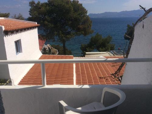 a white chair sitting on a balcony looking out at the water at Rosys Little Village in Skala