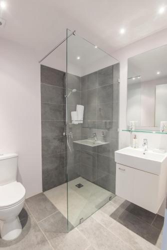 a bathroom with a shower and a toilet and a sink at Minimal Sea View Maisonette in Porto Heli