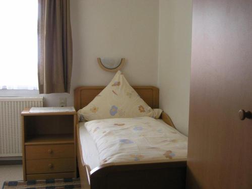 ein kleines Schlafzimmer mit einem Bett und einem Fenster in der Unterkunft Gasthof Post in Großaitingen
