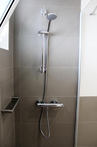 a shower with a shower head in a bathroom at Apartamentos Turisticos Paraiso in Funchal