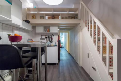 a kitchen with a staircase with white cabinets and a table at Apartment Pierre Scize Sur La Saône in Lyon