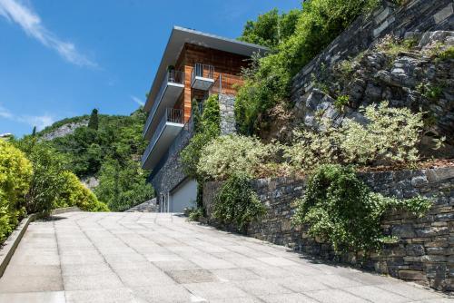 a house on the side of a stone wall at Residenza Luigina in Varenna