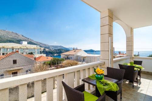 a balcony with tables and chairs and a view of the ocean at Apartment Bonaca in Dubrovnik