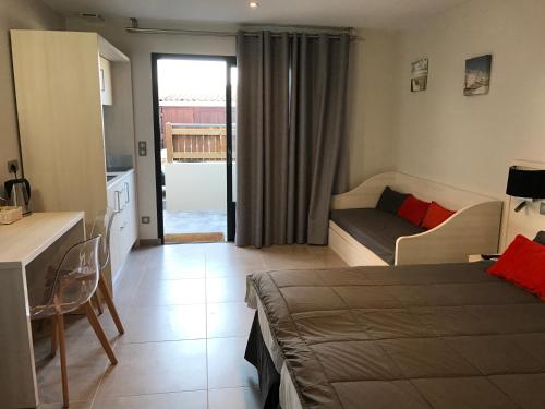 Cet appartement comprend une chambre avec un lit et un canapé ainsi qu'une cuisine. dans l'établissement Les studios du Centre, à La Teste-de-Buch