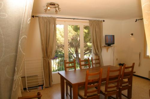 une salle à manger avec une table et des chaises et une fenêtre dans l'établissement Location Corsica, à Cavalaire-sur-Mer