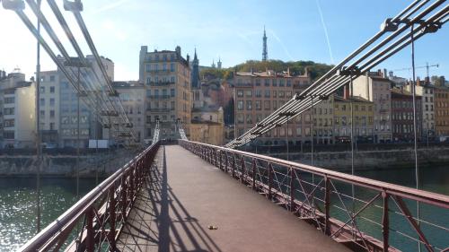 a bridge over a river with buildings in the background at Apartment Pierre Scize Sur La Saône in Lyon
