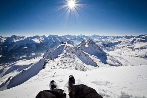 a person sitting on top of a snow covered mountain at Alphütte Bielerhüs in Fiesch