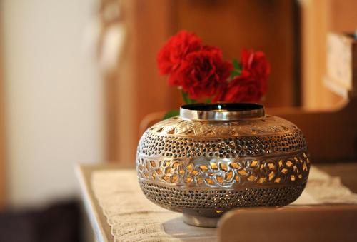 ショペルナウにあるFerienbauernhof Erathの赤い花のテーブルに座る銀の花瓶