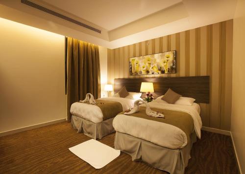 a hotel room with two beds in a room at Hayat Watheer for serviced Apartment in Dammam