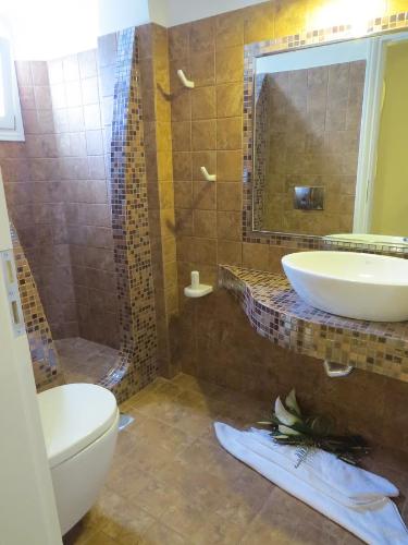 a bathroom with a toilet and a sink and a shower at Villa Manos Hotel in Karterados
