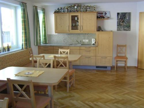 una cocina con mesas y sillas de madera y una encimera en Nadlihof, en Flirsch