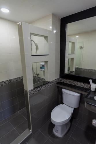 y baño con aseo, ducha y espejo. en Q Space Residence, en Bangkok