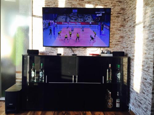 a tv on a wall with a basketball game on it at Ferienwohnung 210 Vitamar in Schmarren