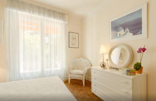 une chambre avec un lit, une commode et une fenêtre dans l'établissement Cannes Film Festival Beach Apartment, à Cannes