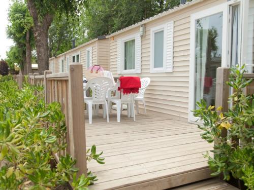 a wooden deck with two chairs and a table at Camping Sènia Caballo de Mar in Pineda de Mar