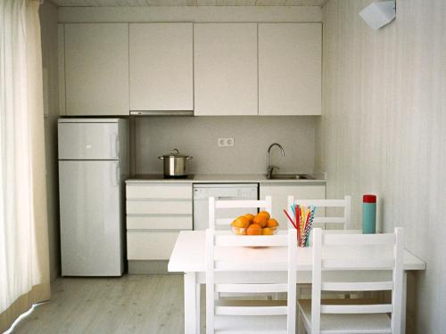 a kitchen with a table and chairs with oranges on it at Camping Sènia Caballo de Mar in Pineda de Mar