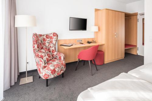 a hotel room with a desk and a chair at BSW Hotel Isarwinkel in Bad Tölz