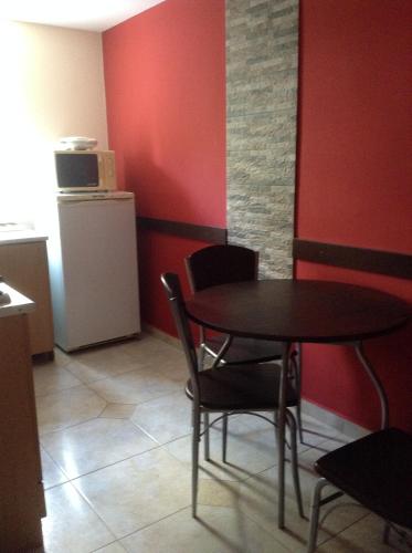 a table and chairs in a room with a red wall at Harsányi vendégház in Miskolctapolca