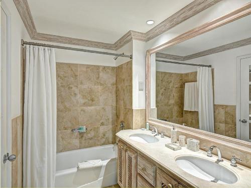 a bathroom with two sinks and a tub and a mirror at Port St Charles unit 248 in Saint Peter