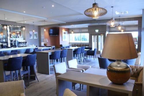 a restaurant with chairs and tables and a lamp on a table at Sligo Park Hotel & Leisure Club in Sligo