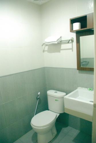 a bathroom with a white toilet and a sink at Avon's Residence in Manado