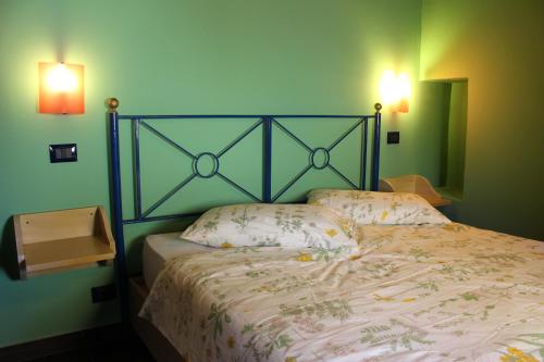 a bed in a room with a green wall at CasaTua Punta Secca in Punta Secca