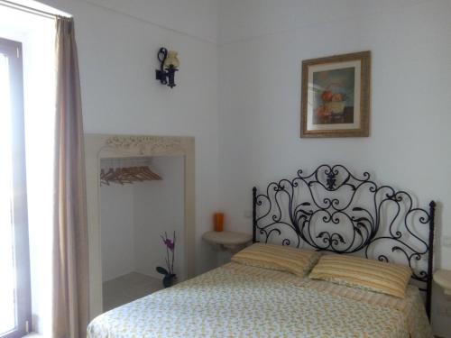 una camera da letto con un letto con copriletto bianco e nero di "Pozzo della Corte" - un Raffinato Nido d'Amore Salentino a Sannicola