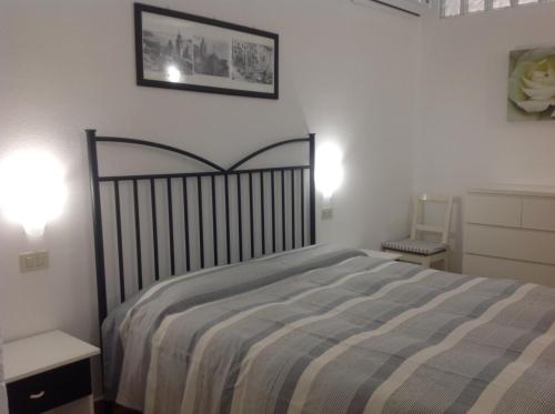 een slaapkamer met een bed met een gestreepte deken bij Affittacamere La Lanterna in Portovenere