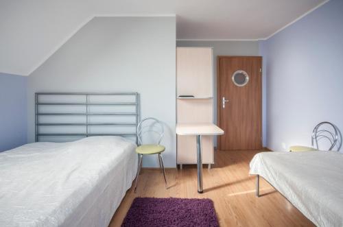 a bedroom with two beds and a table and chairs at Roza Wiatrow in Chłopy