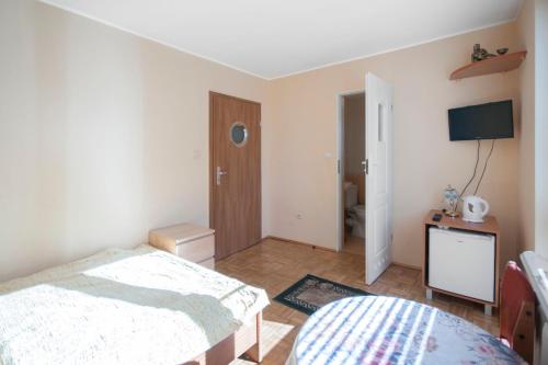 a bedroom with a bed and a television in it at Roza Wiatrow in Chłopy