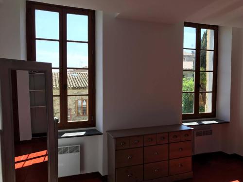 カルカソンヌにあるAppartement au coeur de Carcassonneのベッドルーム1室(窓2つ、鏡付きドレッサー付)