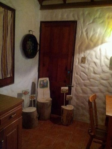 a bathroom with a toilet and two stools in front of a door at Casa Benjaim in Punta Del Diablo
