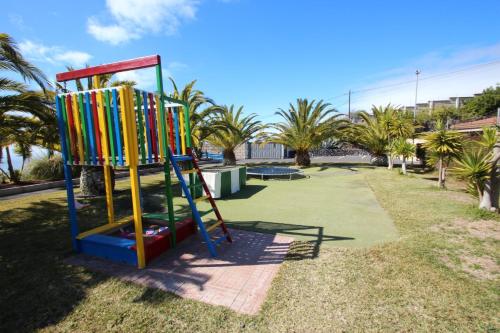 a playground with a colorful slide in a park at Suite Mariposa Finca Montimar in Chio