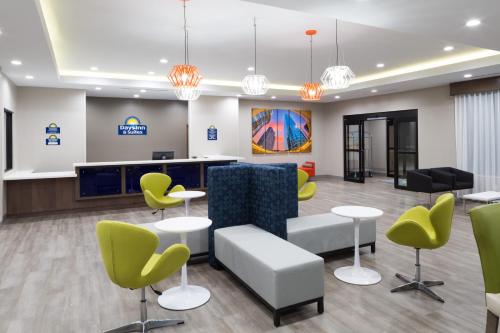 a lobby with a waiting area with chairs and tables at Days Inn & Suites by Wyndham Houston NW Cypress in Cypress