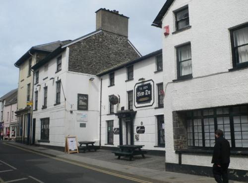 un homme marchant dans une rue devant un bâtiment dans l'établissement Bridge Street, à Aberystwyth