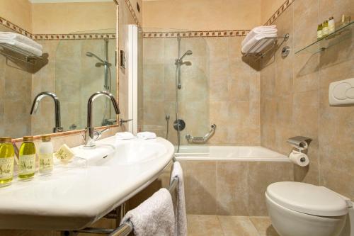 La salle de bains est pourvue d'un lavabo, de toilettes et d'une baignoire. dans l'établissement Hotel Athena, à Sienne