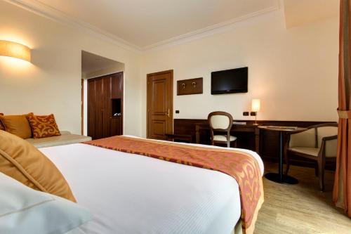 a hotel room with a bed and a desk at Hotel Athena in Siena