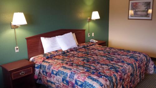 a hotel room with a bed and two lamps at Family Budget Inn Harrison in Harrison