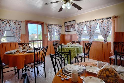 a dining room with tables and chairs and windows at Chester's Bonefishing Lodge in Chesters