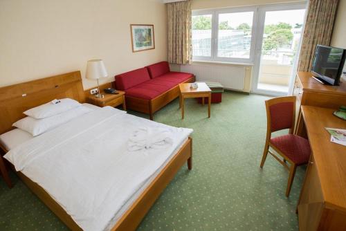 a hotel room with a bed and a red couch at Badener Hof in Baden