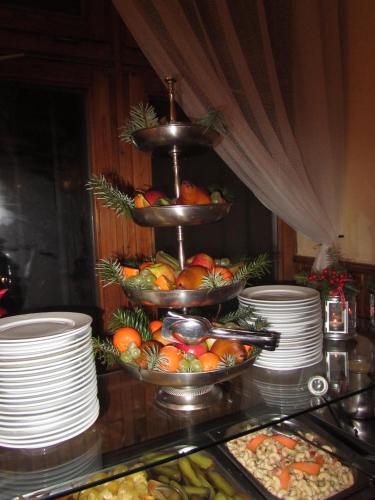 a display of food on a table with plates and fruit at Hotel Síkfőkút in Noszvaj