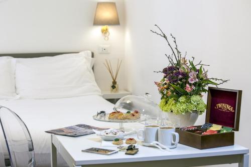 una camera d'albergo con letto e tavolo con cibo di Napoli Class a Napoli
