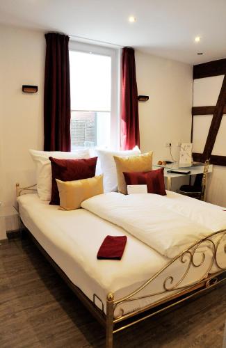a bedroom with a large white bed with a window at Hotel Restaurant Krehl's Linde in Stuttgart