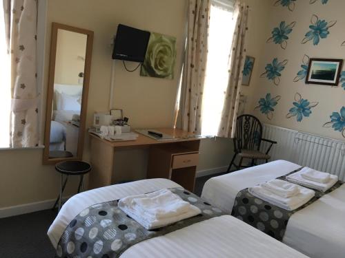 a hotel room with two beds and a mirror at The Address in Blackpool