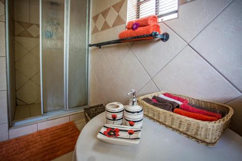 a bathroom with a sink and baskets of towels at Manzini Cottage in Marloth Park