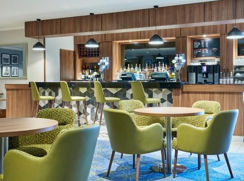 a restaurant with tables and chairs and a bar at Leonardo Hotel Cheltenham in Cheltenham